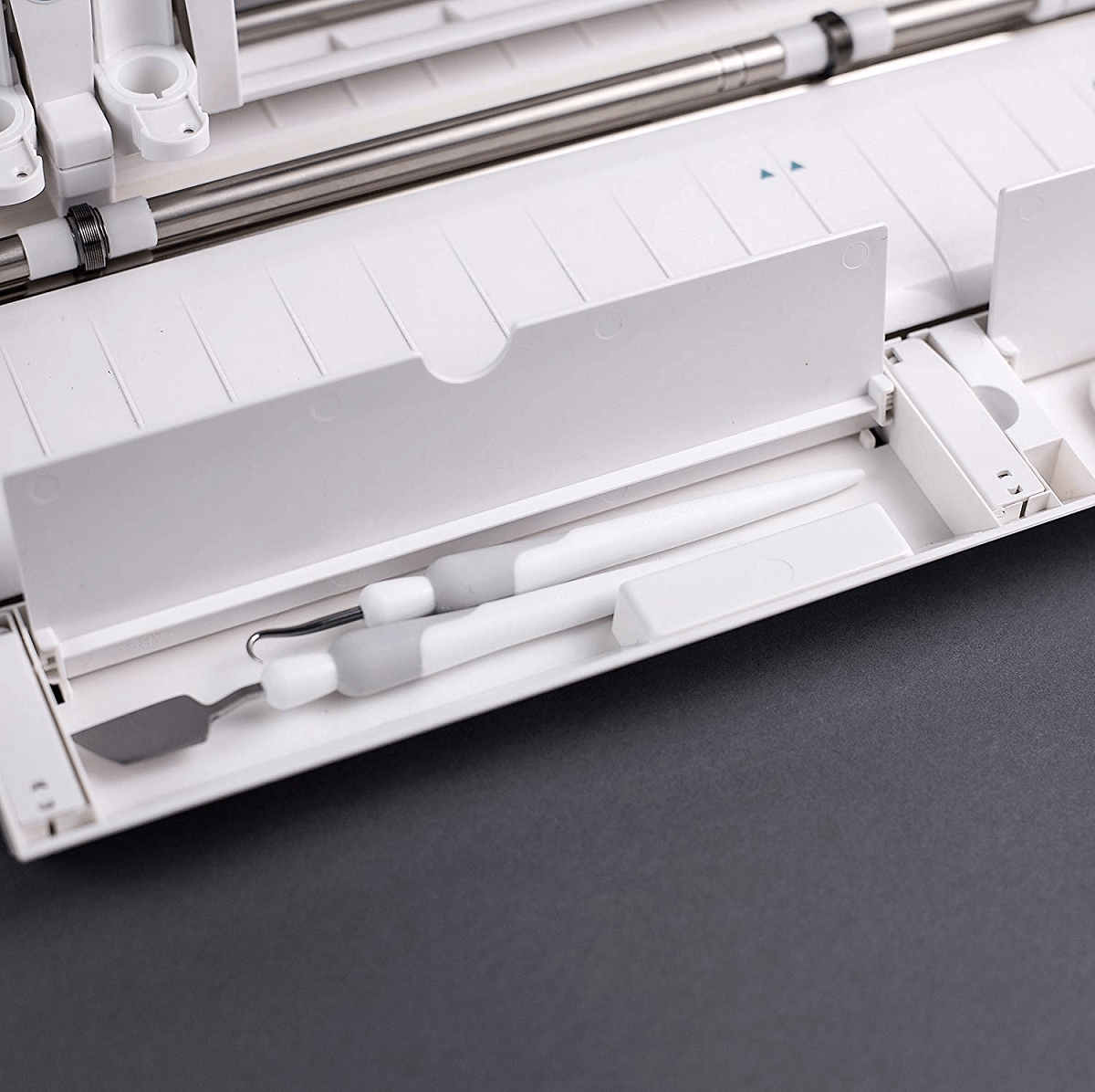 Silhouette Cameo 3 has two hidden compartments. A long one for pens and tools and a short one for pen blades.