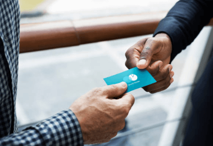 Man handing a business card to another man